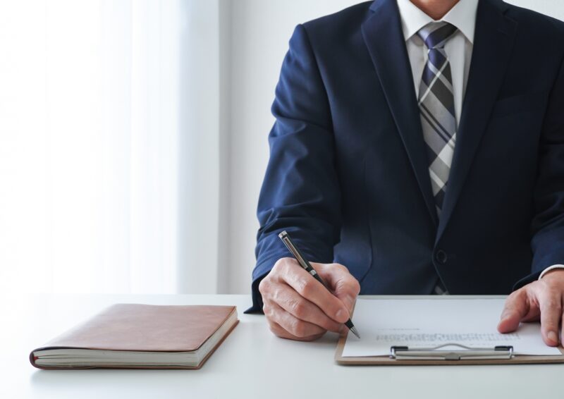 デスクで記入するビジネスマン