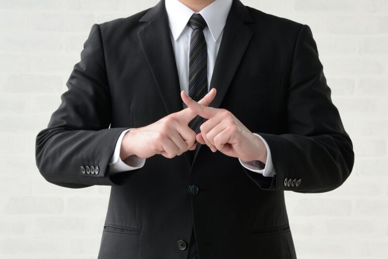 バツ印をつくるビジネスマン