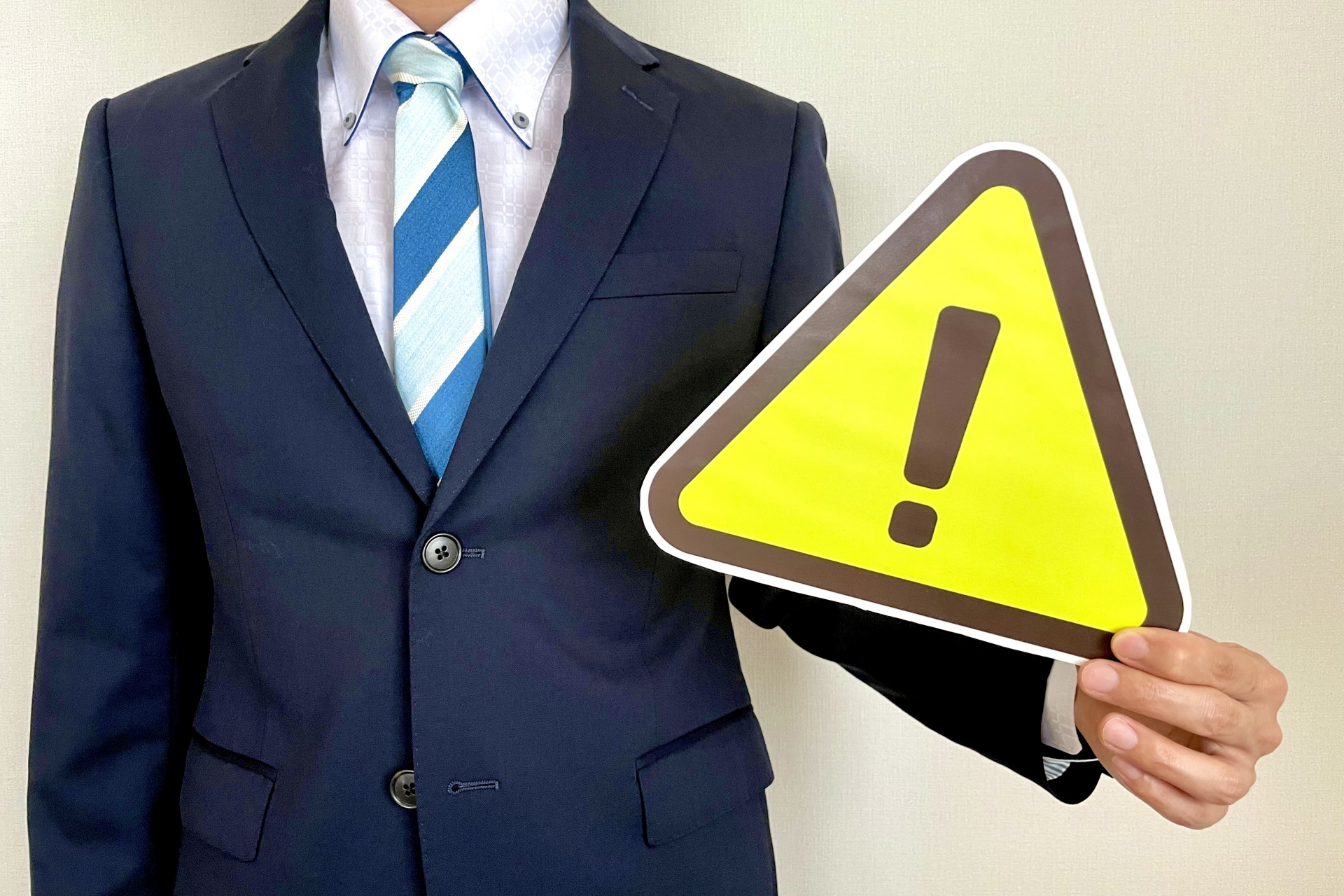 注意マークを横に持つ男性
