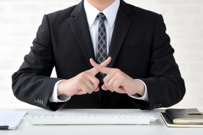 バツ印をつくるビジネスマン