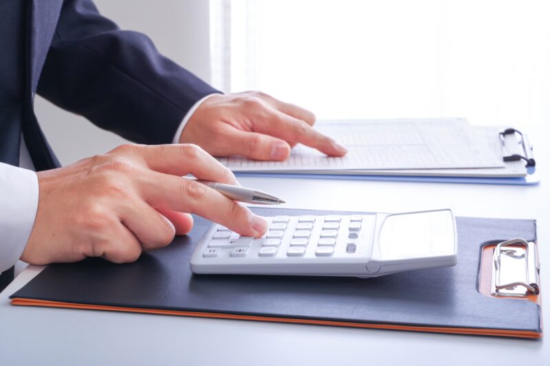 電卓でお金の計算をする人の手元