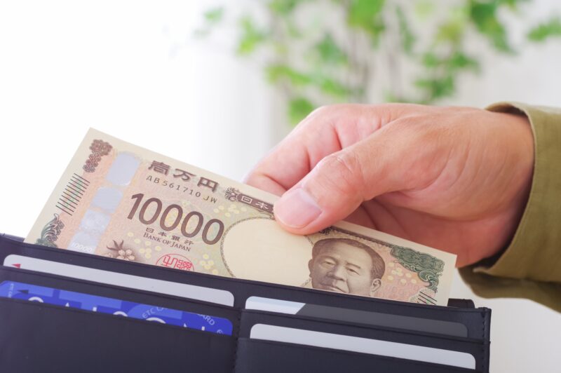 財布からお金を取り出す男性