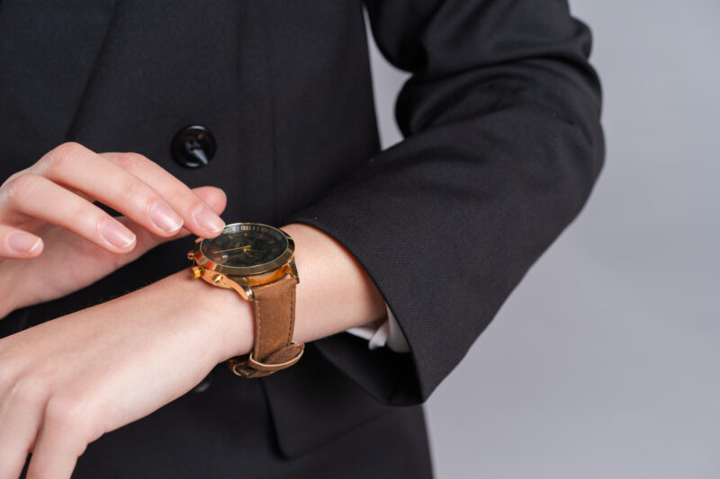 腕時計を指で触る人の手