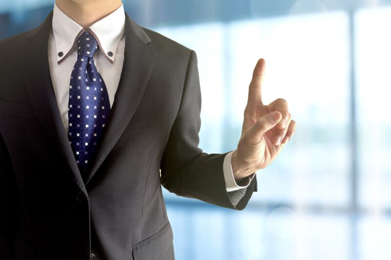 指差しするサラリーマンとオフィス背景