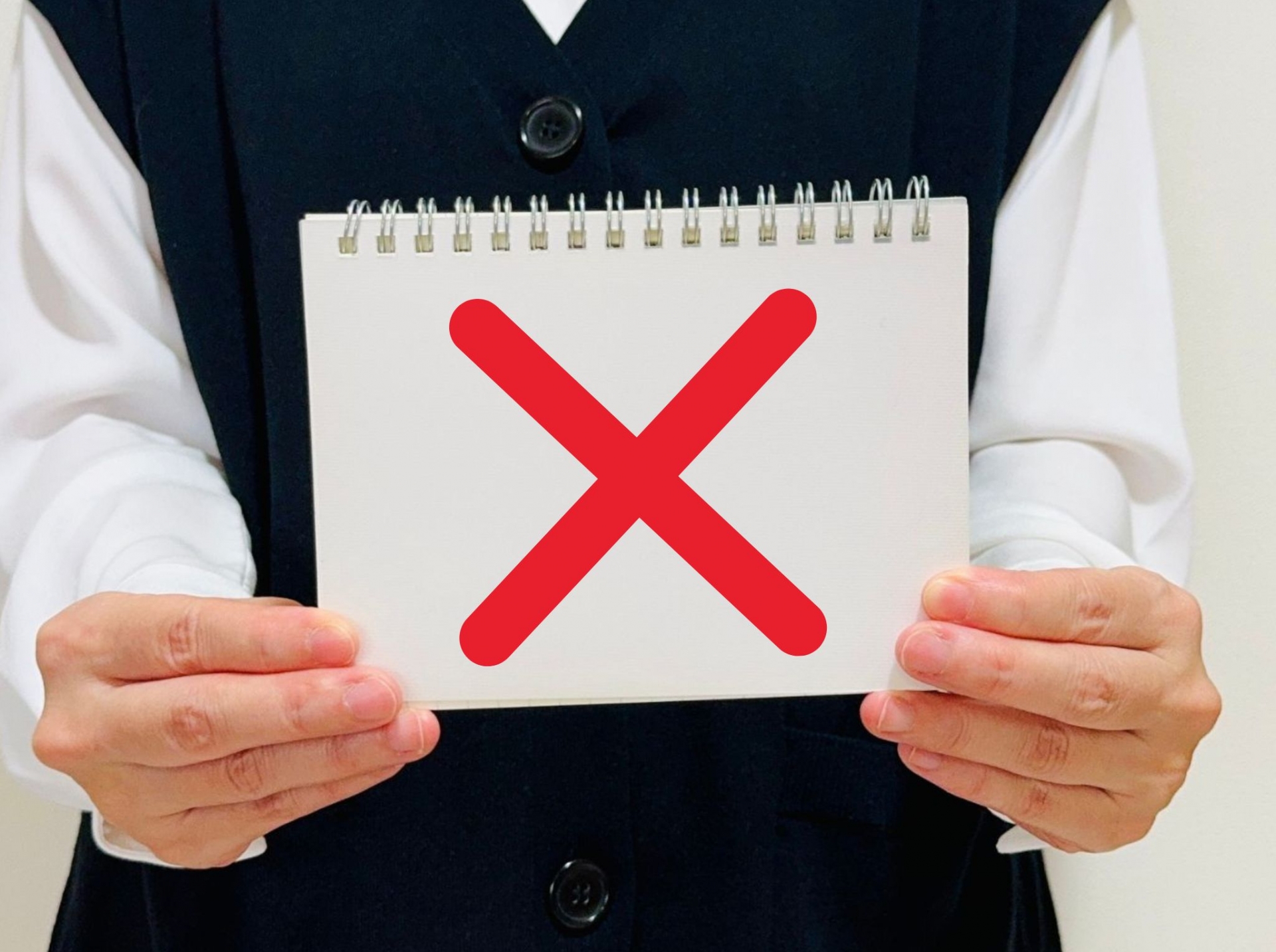 バッテンマークが書かれたノートを持つ女性