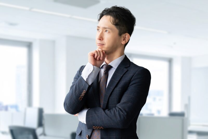 考えごとをする男性ビジネスマン