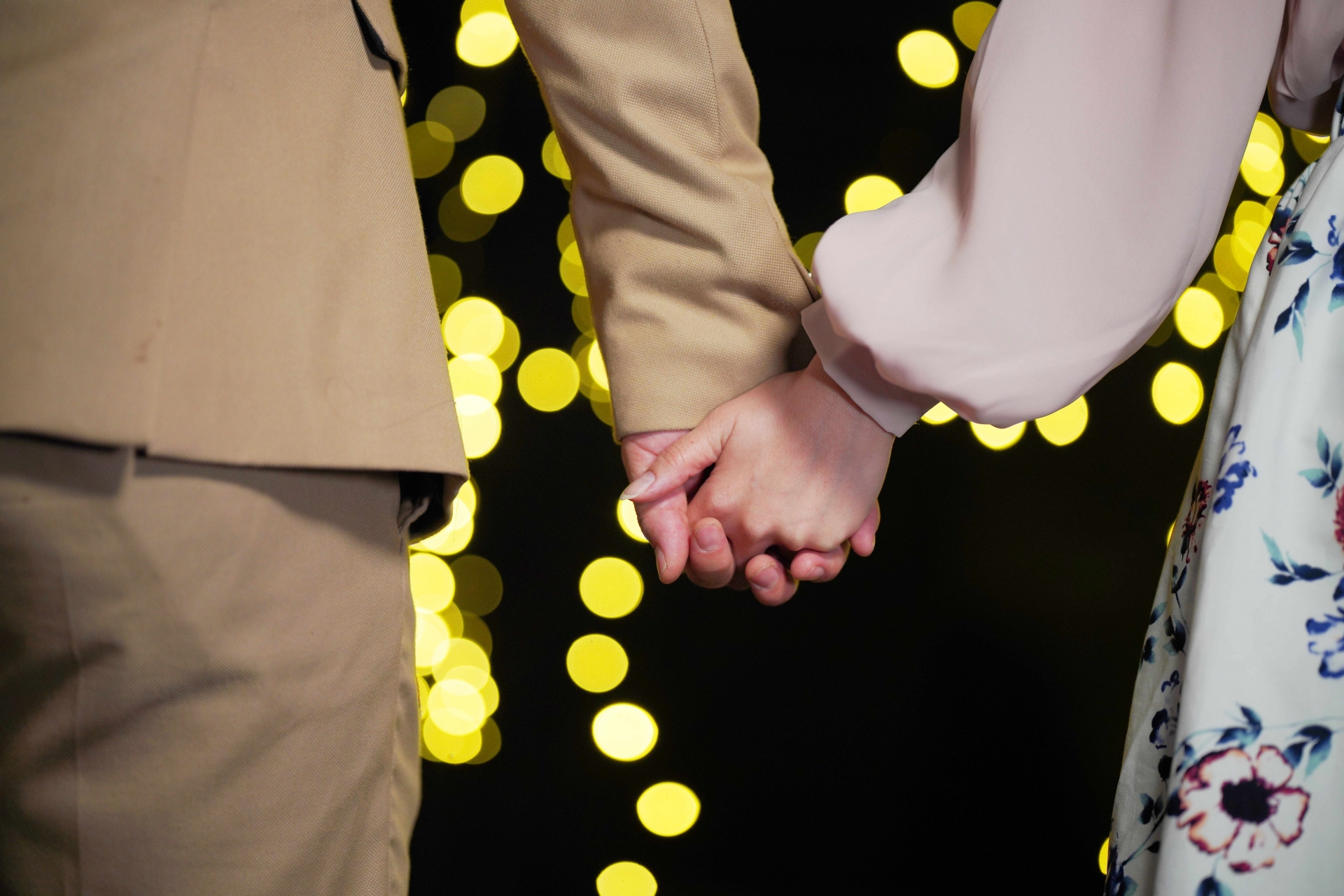 手を繋ぐカップルの手元