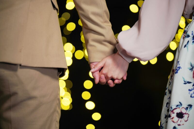 手を繋ぐカップルの手元