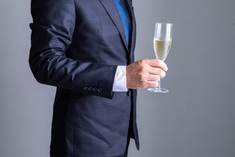 シャンパングラスを持ったスーツの男性