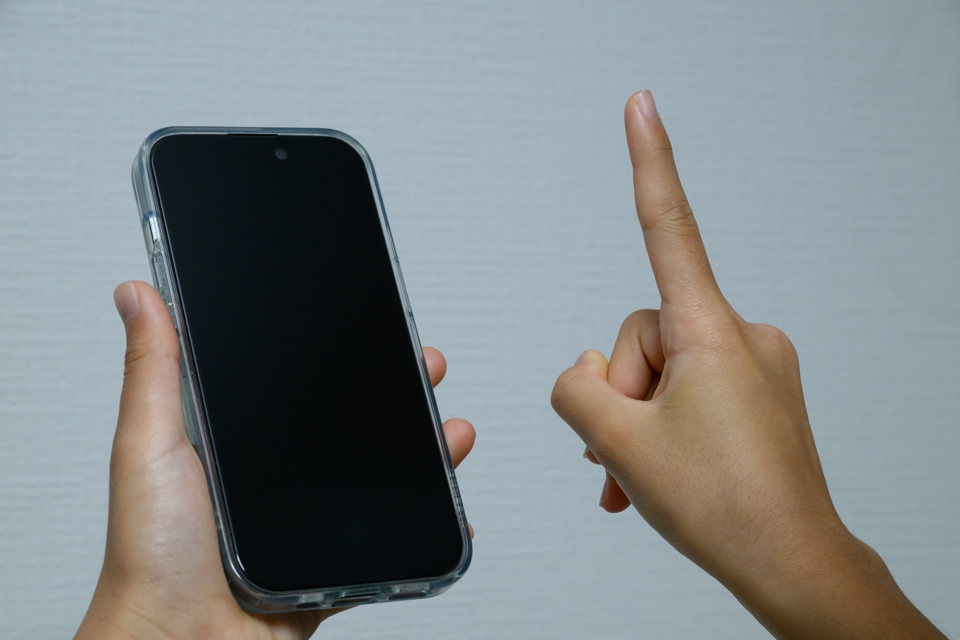 スマートフォンを指差して操作する手元