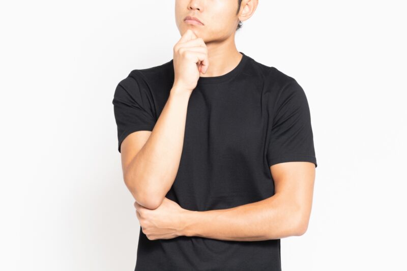悩んでいる黒いTシャツを着ている男性