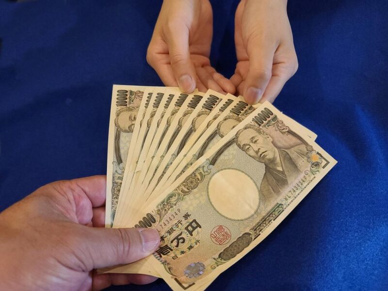 扇状に広げた一万円札を持つ手（料金のイメージ）
