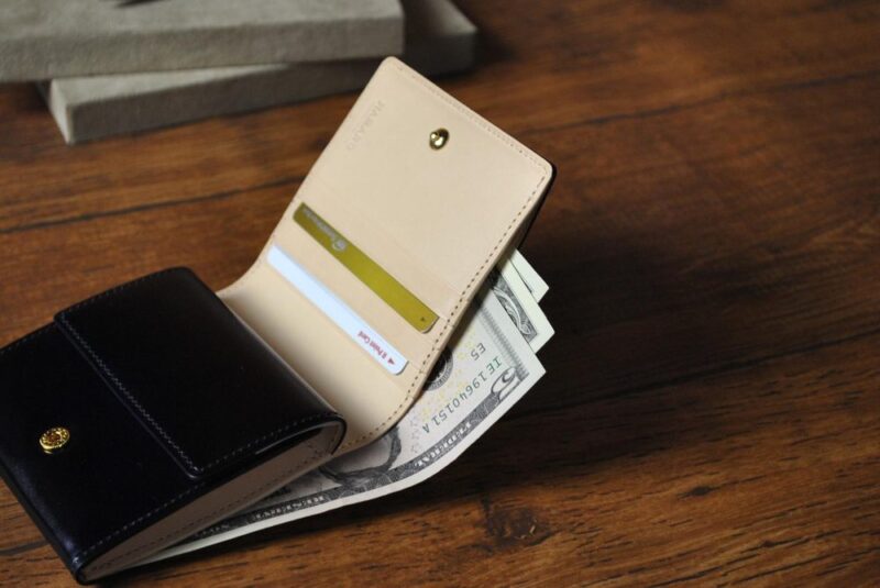 木のテーブルに置かれたカード入りの財布