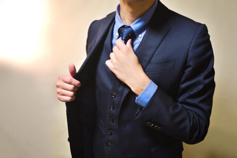 紺色のスーツを整える男性