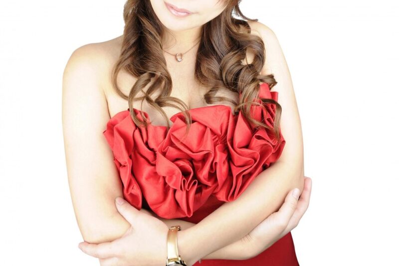 赤いドレスで腕を組む女性