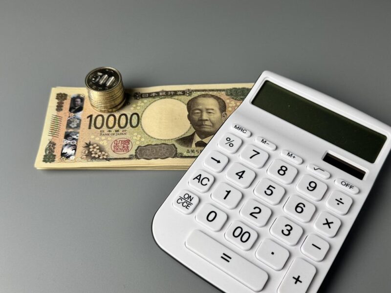 一万円札の上に置かれた電卓(プレゼントの予算・相場のイメージ)