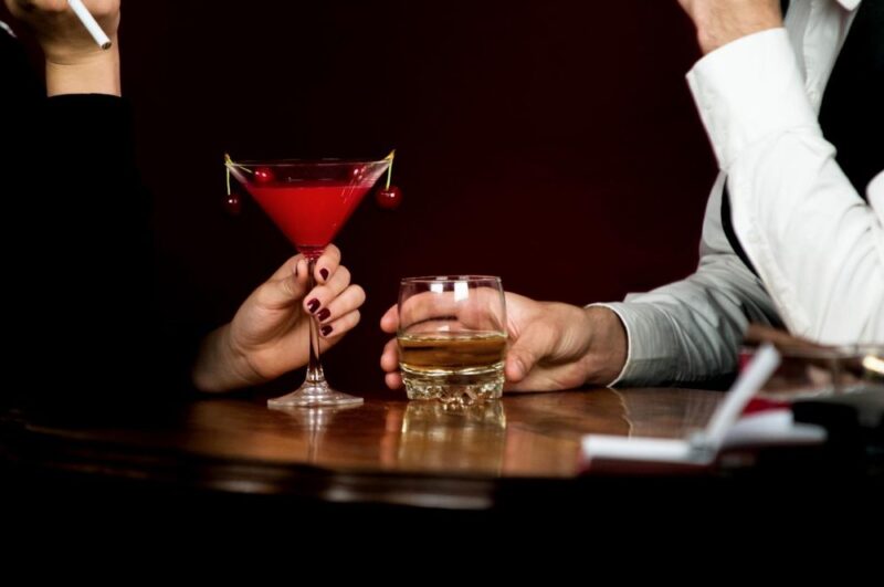 薄暗い店内のテーブルに置かれた赤いカクテルとお酒